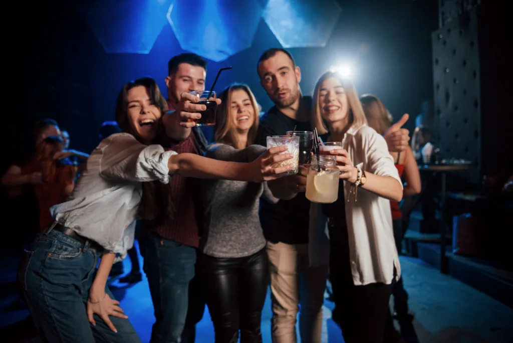 Group of friends raising drinks together in a nightclub