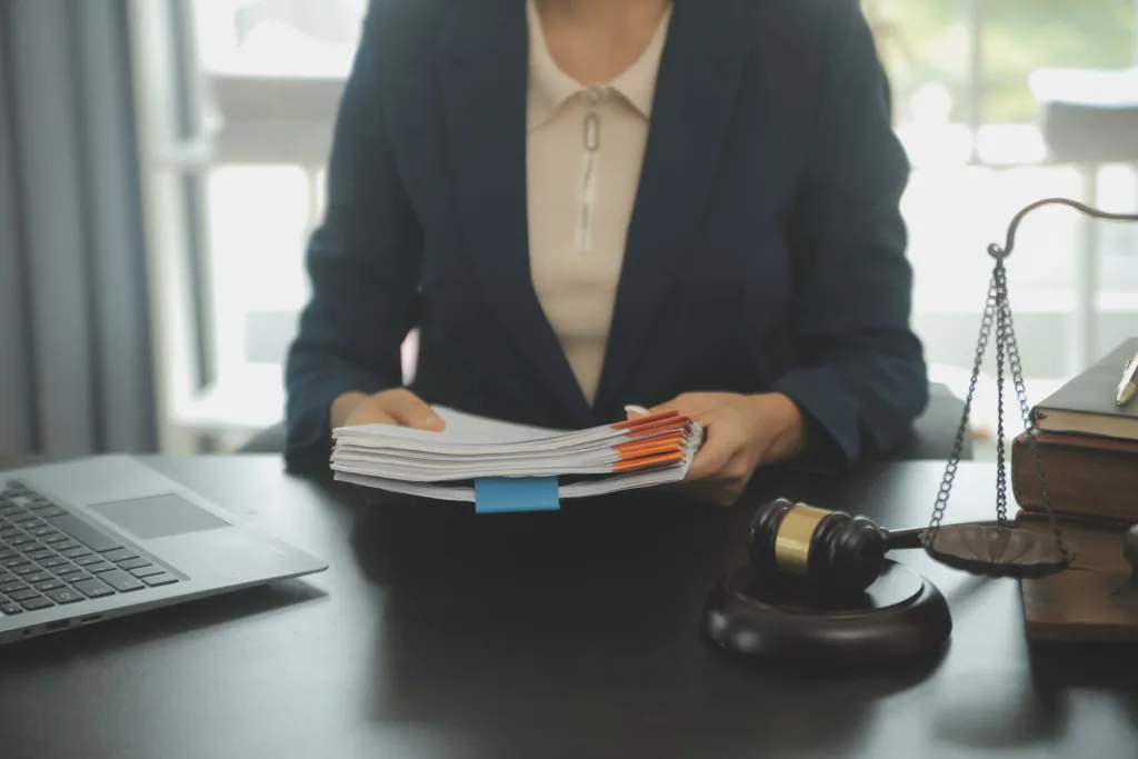 Attorney reviewing case documents beside a gavel and scales of justice