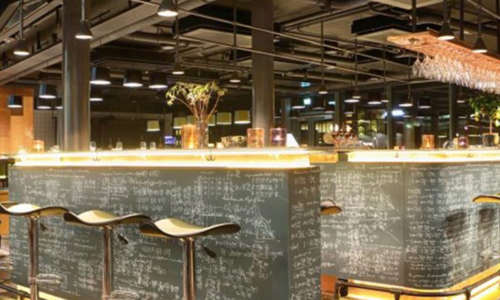 A bar counter with a chalkboard back wall